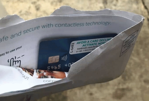 A credit or debit card, partially visible inside an open envelope