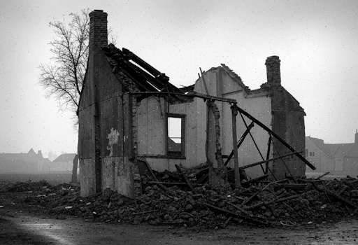 A black and white photograph of a bombed cottage