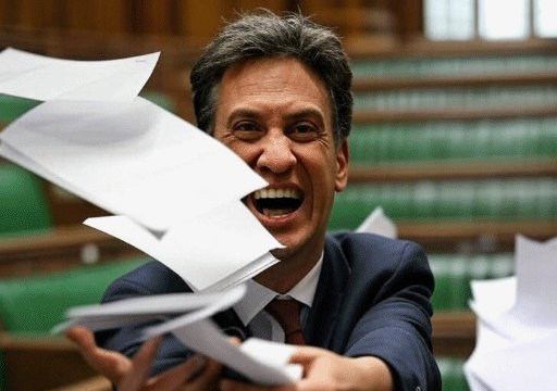 Ed Miliband throwing some papers while laughing in the House of Commons